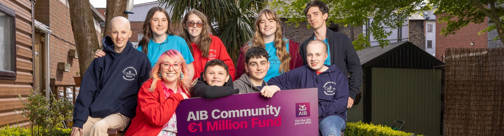 Group of boys and girls with banner saying AIB Community 1 Million Fund Charities!
