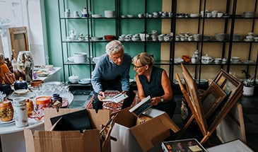 Lady shopping in an antiques store asking the shop owner for support