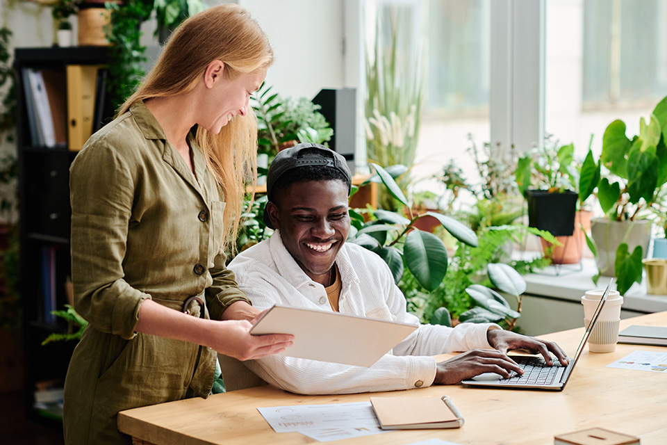 Two office workers completing their sustainability template
