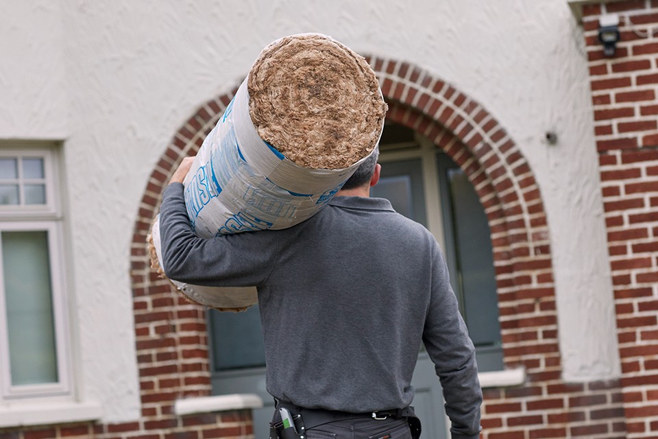 Man carrying insulation for a home.