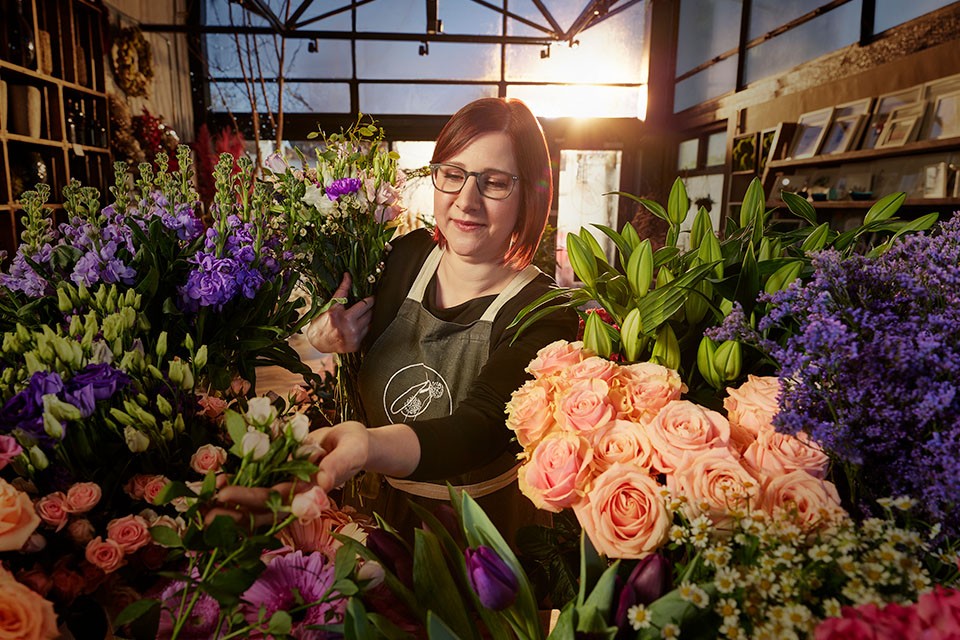 Woman cutting flowers in flower shop